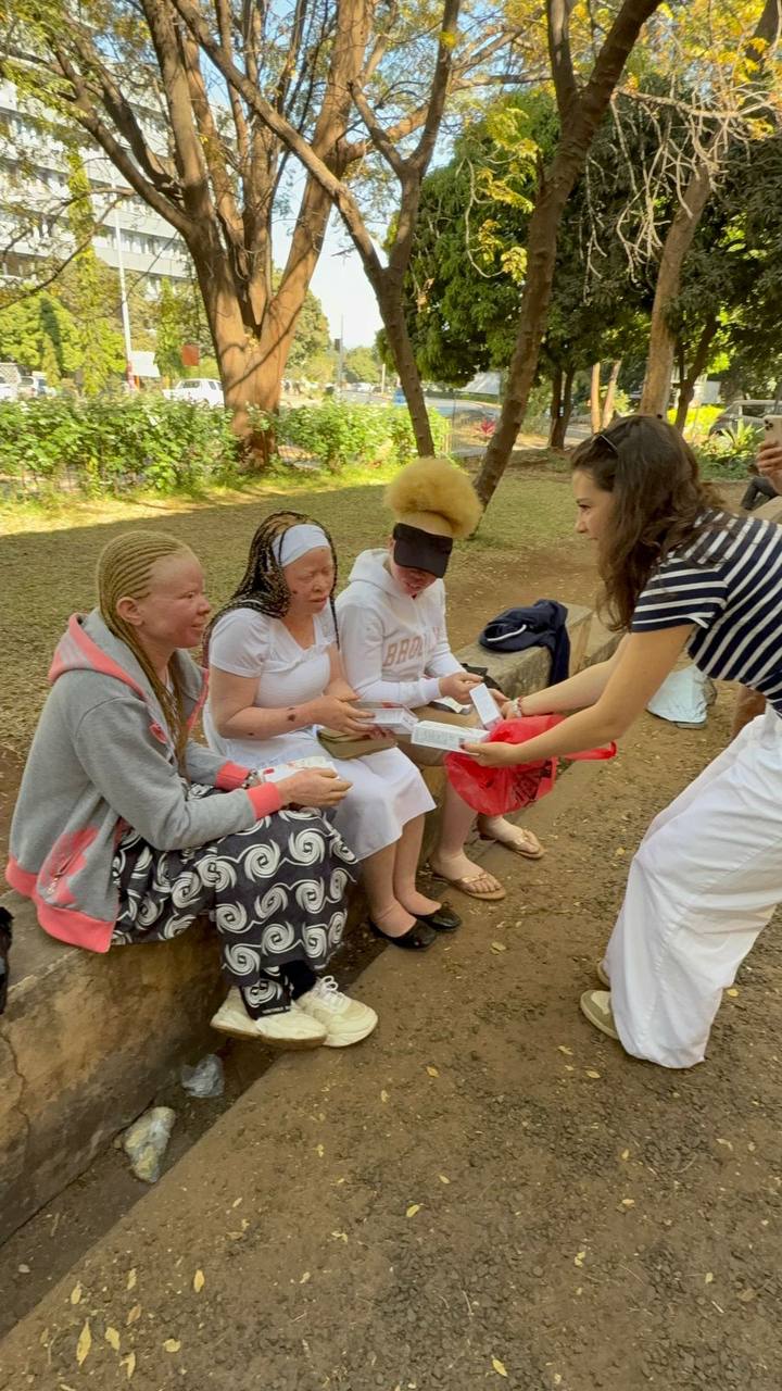 Carolina Khaskelis distributing sunscreen to the albinism community in Zambia